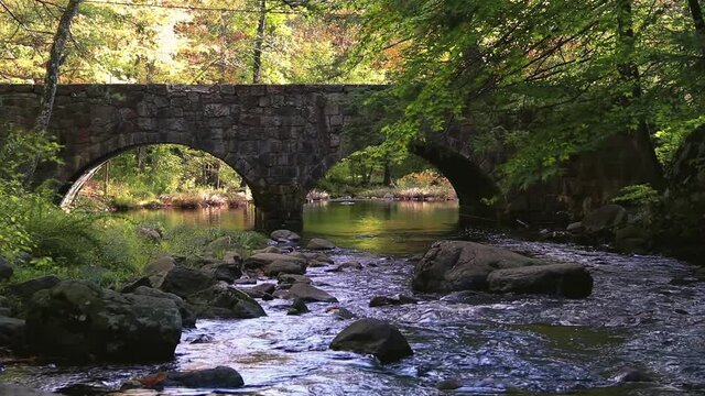 Double Arch stone bridge over gently flowing Flatbrook River in Stokes State Forest, NJ, in fall