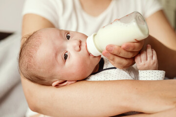 baby eats milk from a bottle