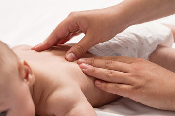 Fototapeta na wymiar baby massage, close-up hands on baby back