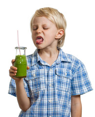 Boy poking tongue out at green smoothie
