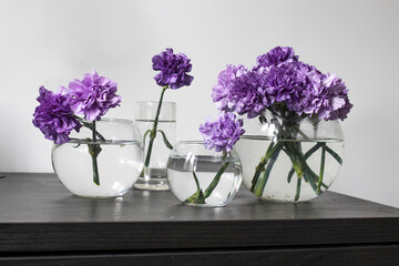 Bridal bouquet of lilac carnations in a round glass vase