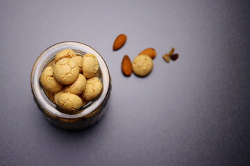 Fototapeta na wymiar Italian amaretti cookies in a glass jar on a gray background. Crunchy macaroons.