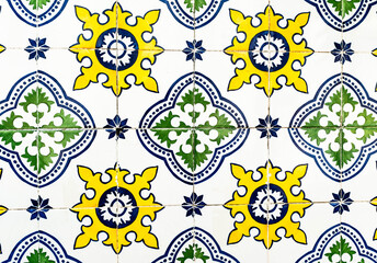 Portuguese traditional tiles Azulejos with blue, green and yellow floral pattern on a white background.