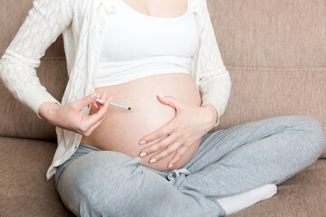 Pregnant woman with insulin syringe in home on bed. Pregnant diabetes concept