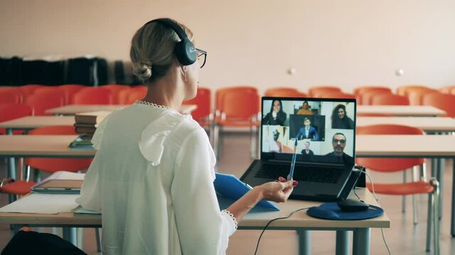 A woman is teaching adult students via the internet