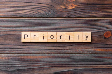 priority word written on wood block. priority text on table, concept