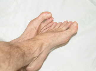 naked legs of a man on a white towel.