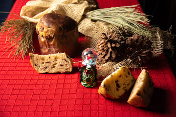 Christmas table. Details of a beautiful Christmas table with red tablecloth and a Christmas tree in the background. Low key image. Small depth of field, selective focus.