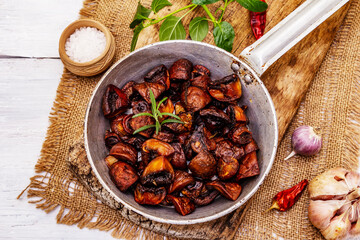 Ready to eat hot fried brown champignons in vintage pan