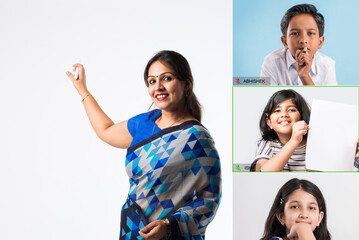 Portrait of asian Indian lady teacher in saree stands against writing board conducting online class