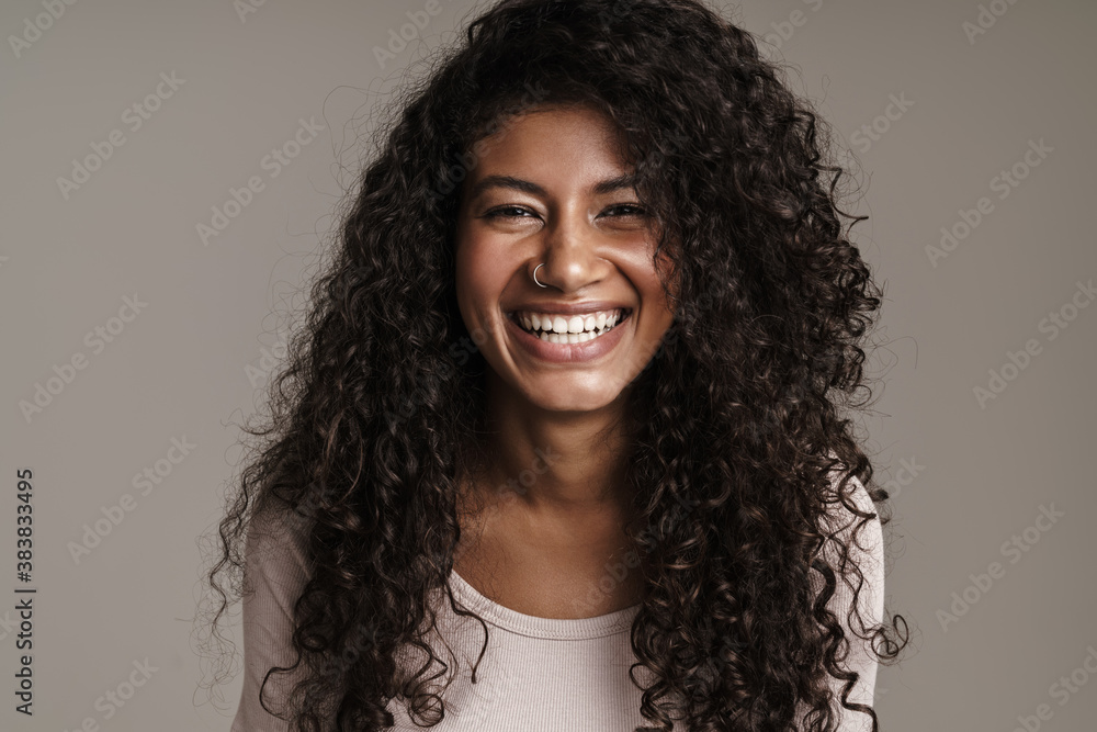 Wall mural cheerful dark-skinned girl standing isolated