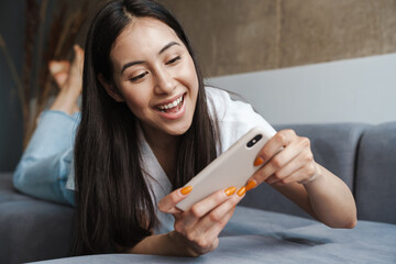 Woman at home indoors lying on a sofa