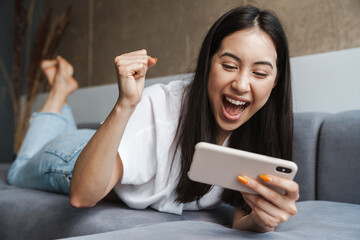 Woman at home indoors lying on a sofa