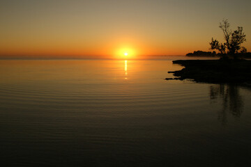 Fototapeta na wymiar dawn on a tropical island. dawn in the tropics. calm water in which the rising sun is reflected