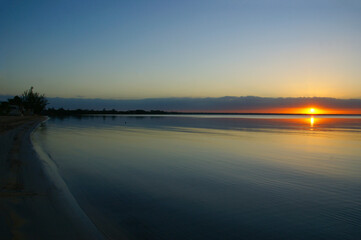 dawn on a tropical island. dawn in the tropics. calm water in which the rising sun is reflected