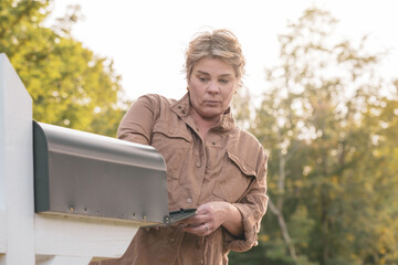 Attractive Full FIgure Woman Reaching into a Mailbox
