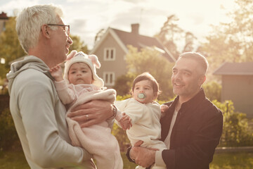 Smiling fathers holding small daughters