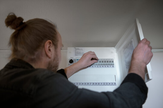 Man checking fuse box at home