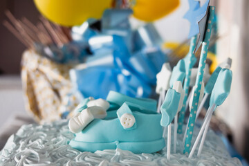 Cream and cream fondant cake with shoes with bows and buttons and stars for party or child...