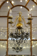 Reflection of chandelier in classic mirror.