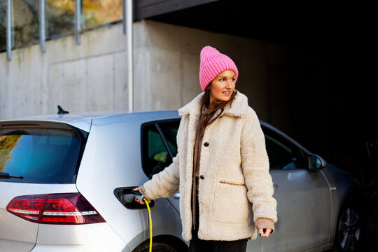 Woman charging electric car