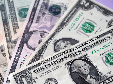 A photo illustration of US various dollar bills ibackground. Selective focus. 1 dollar bill at fioregraund