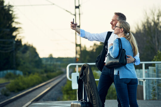 Couple taking selfie at train station platform