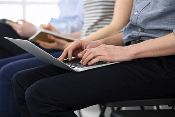 Group of casual dressed business people working at meeting or conference, close-up of hands. Businessman using laptop computer. Teamwork or coaching concept