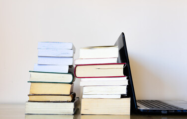 Two columns of books, and next to them a laptop computer. Perhaps with one of the objects that we are replacing the reading and the books.