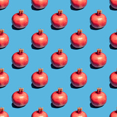 Seamless pattern with pomegranate fruit on blue background.