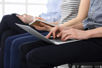 Group of casual dressed business people working at meeting or conference, close-up of hands. Businessman using laptop computer. Teamwork or coaching concept