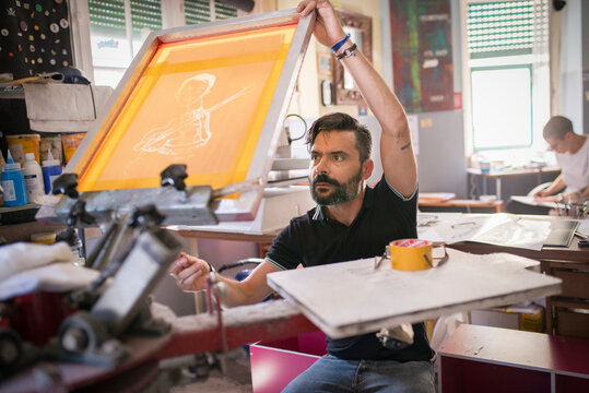 Man operating screen printing equipment