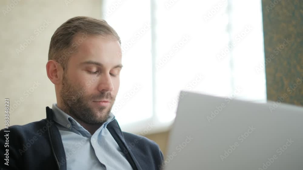 Poster remote job. a man is working with documents on laptop remotely at home. a business man is using comp