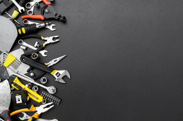 Many different tools for repair work on a black background with copy space for text.