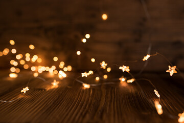 Christmas lights on dark wood.
Golden christmas lights and bokeh on dark wood. Blurred lights...