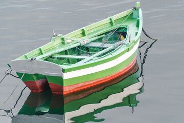 Fototapeta na wymiar View of a fishing boat reflecting in a calm sea