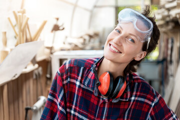 Young beautiful handy professional happy female strong carpenter portrait wearing protective...