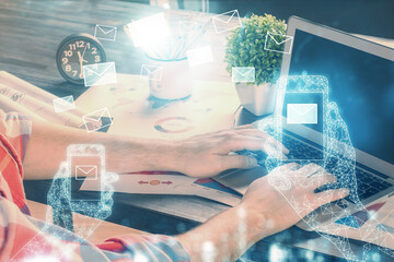 Envelop holograms with businessman working on computer on background. E-mail concept. Multi exposure.