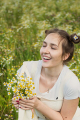Young girl. Chamomile field. Beige jumpsuit.