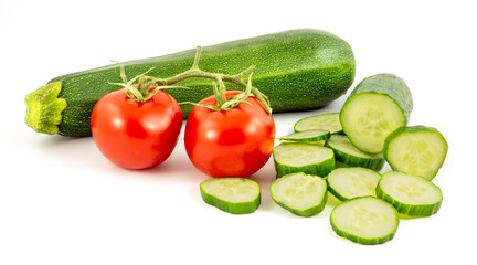 Sliced green cucumber, 2 red tomatos and green zucchine isolated on a white background.