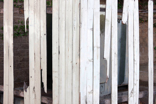 An Old Damaged White Painted Lattice Cage To Shield A Large Outdoor Transformer In The Corner Of On An Empty Abandoned Parking Lot