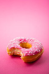 Studio shot of a colorful donut on pink background.