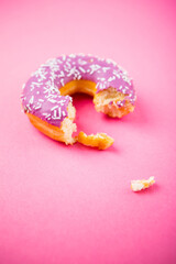 Studio shot of a colorful donut on pink background.