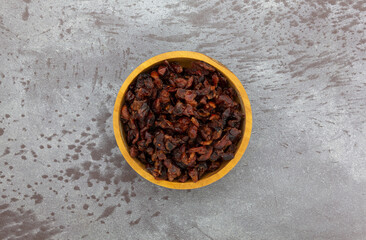 Baking cranberries in a wood bowl on a gray background.