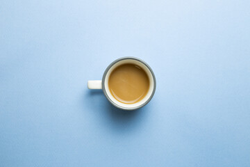 Cup of coffee on blue background. top view, copy space