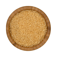 Bowl of raw sugar isolated on a white background