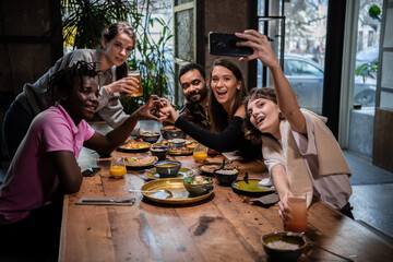 Group of students making faces, taking pictures with the smartphone.