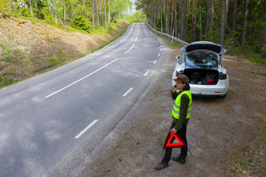 Man on side of road with broken down car
