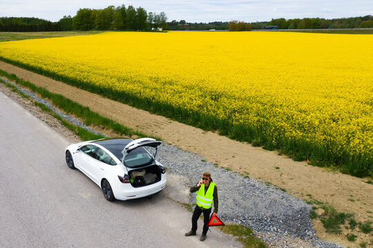 Man on side of road with broken down car