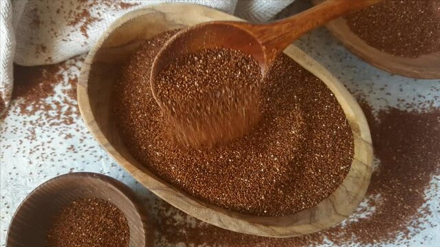 Raw teff grain in a wooden bowl close up